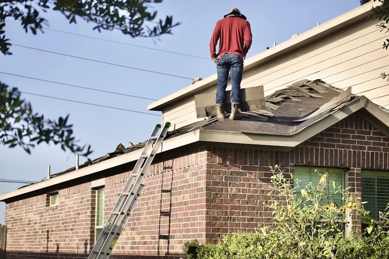 Professional roofer working on a residential roof in Tallevast